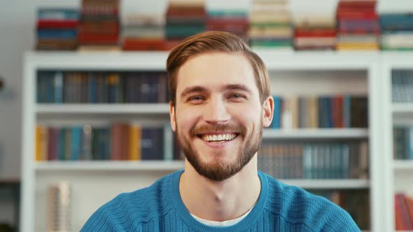 Smiling young teacher on the background of books