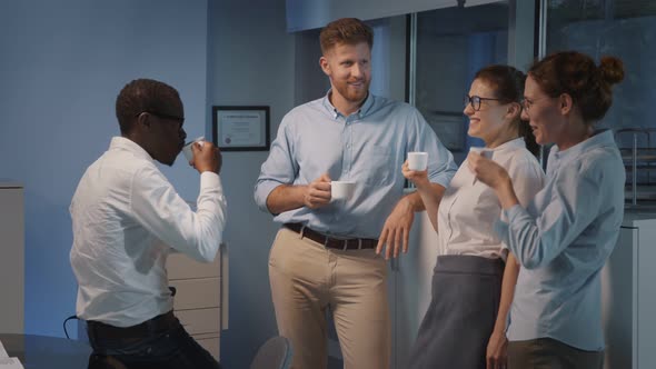 Young Multiethnic Coworkers Having Fun Conversation During Coffee Break in Modern Office