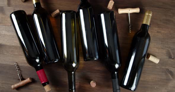 Wine Bottles with Corks and Corkscrews Rotate Slowly. On a Wooden Background.