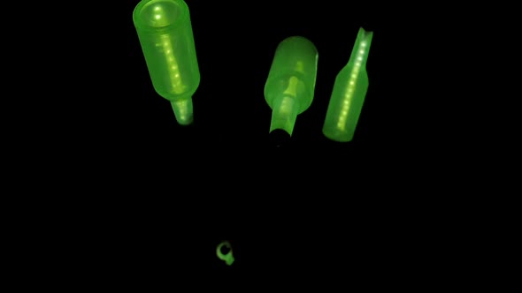Glowing Green Bottles Being Juggled in the Dark by Invisible Juggler