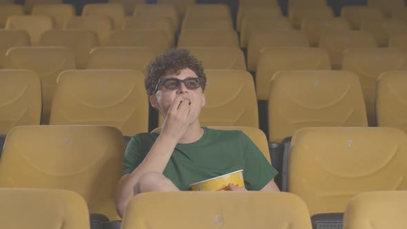 Happy Caucasian Man Watching Film in 3d Cinema and Eating Popcorn. Portrait of Joyful Relaxed Guy