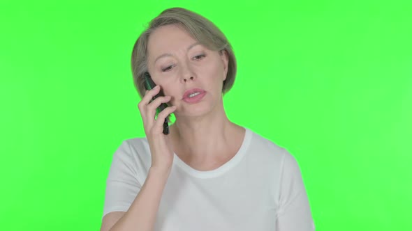 Old Woman Talking on Phone on Green Background