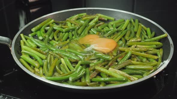 Breaking eggs into frying pan