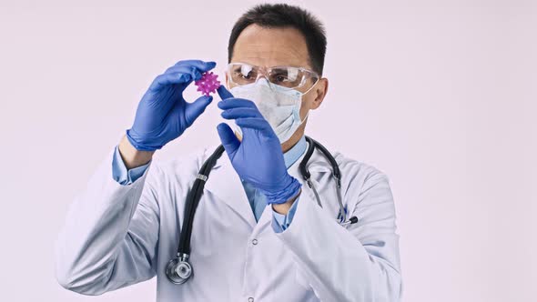 Handsome Lab Technician in Protective Mask Exploring Covid-19 Virus Cell