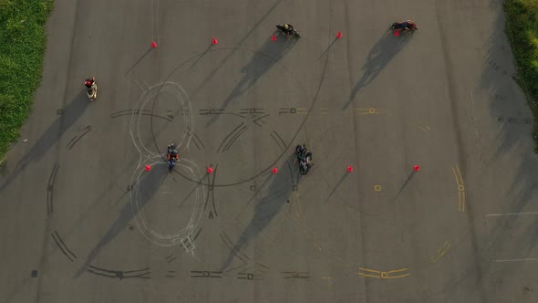 top down wide aerial view of multiple riders practicing on an advanced motorcycle training slalom co