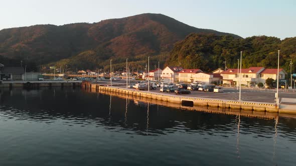 Aerial upwards over small Japanese fishing village at sunrise