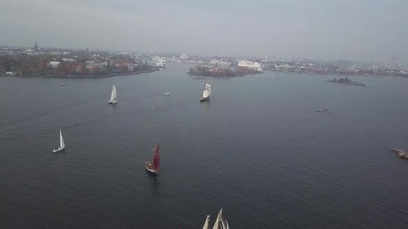 Aerial footage of tradtional wooden sailing ships sailing in front of port of Helsinki Finland
