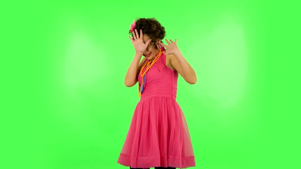 Girl Carefully Examines Something Then Fearfully Covers Her Face with Her Hand. Green Screen at