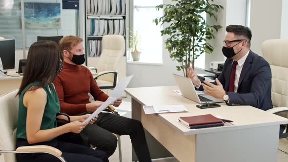 Financial Advisor in Face Mask Talking to Clients