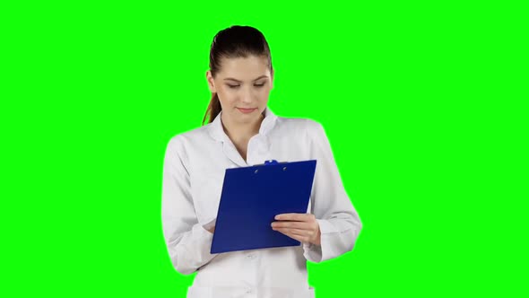 Health Worker Takes Notes on Clipboard. Green Screen