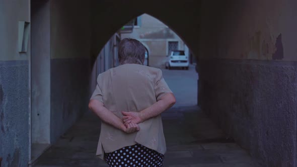 Elderly Woman Strolls Through Cosy Courtyard of Chioggia