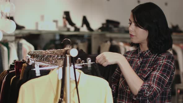 Young adult female looking at clothes in shop