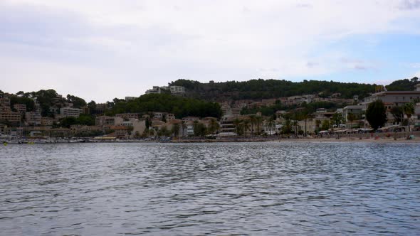 The beach of Port D’Sóller, Mallorca, seen from the pier with the city and mountains in the backgrou