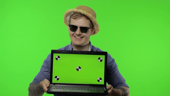 Portrait of Young Man Tourist in Sunglasses Showing Laptop. Chroma Key