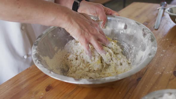 Caucasian female chef mixing dough in a bowl