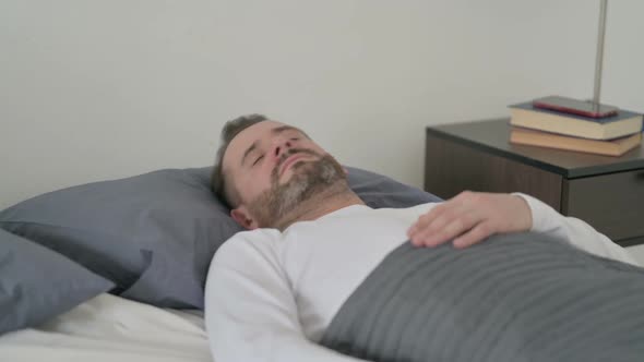 Man Having Headache While Sleeping in Bed