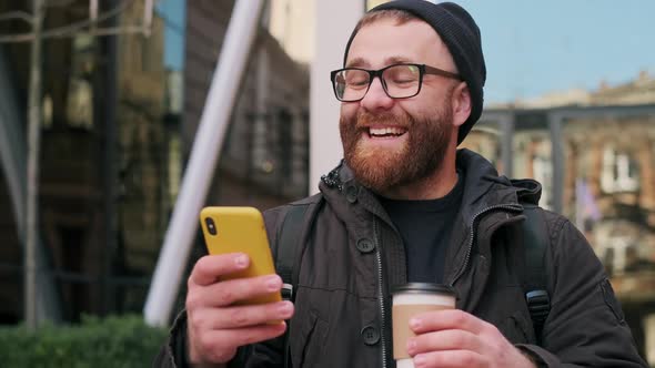 Close Up View of Bearded Man Singing Song and Funny Moving While Walking at Street. Cheerful Guy in