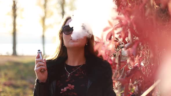 Young girl using ecig evaporation gadget to quit smoking nicotine cigarettes.