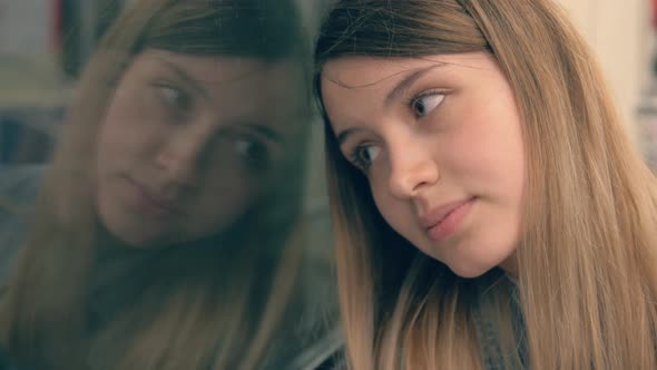 Young Caucasian Woman In A Subway Car With Sadness Looking Out The Window