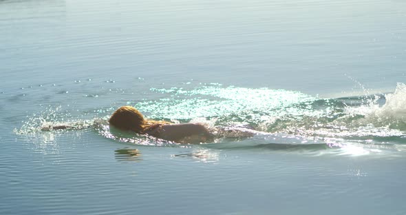 Woman swimming in the water at beach 4k