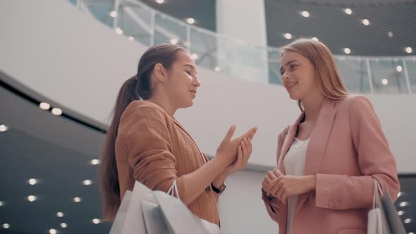 Happy Female Friends Chatting in Mall