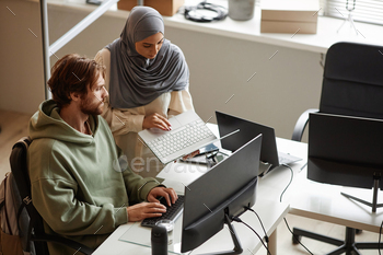 Female Computer Programmer Wearing Headscarf in Office During Code Review