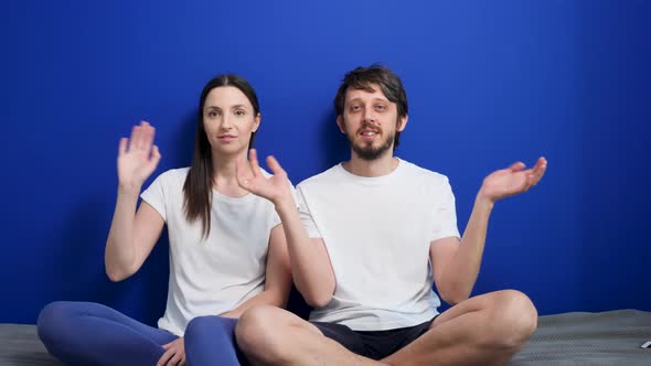 Man with a Beard and a Woman in White T-shirts Are Sitting