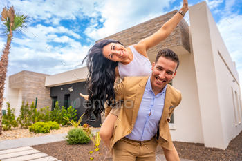 Woman piggybacking her couple celebrating to buy a new home