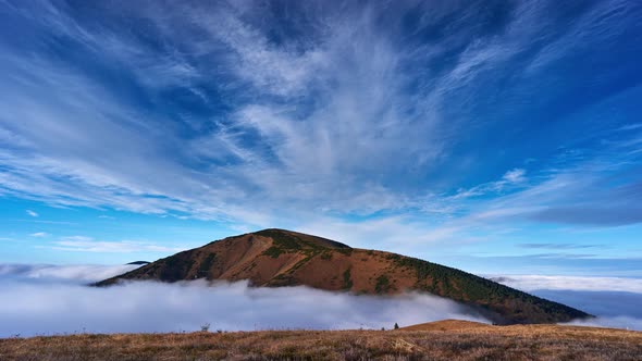 Inverse clouds moving around the top of a mountain in a national park. Zoom out