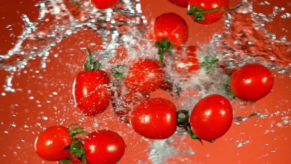 Super Slow Motion Shot of Flying Fresh Tomatoes and Water Side Splash at 1000Fps.