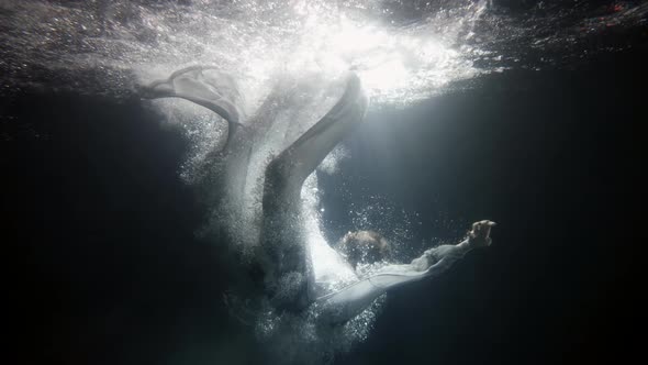 Young Woman Is Plunging Inside Water Underwater Shot Slow Motion Silhouette of Body