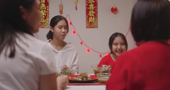 Happy Chinese Family Eating Dinner For Chinese New Year Celebrations Together At Home.