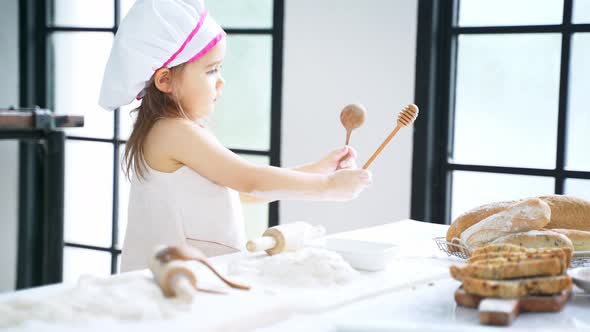 Little Girl Preparing Dough and Bake Cookies in the Kitchen While Learning in the Class at School
