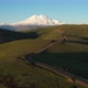 Top view of green field, winding roads and Caucasus mountains.Sunrise above Mount Elbrus - VideoHive Item for Sale