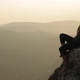 A young woman sitting on top of a mountain - VideoHive Item for Sale