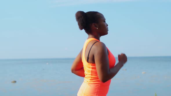 Young African American Woman Running at Seaside