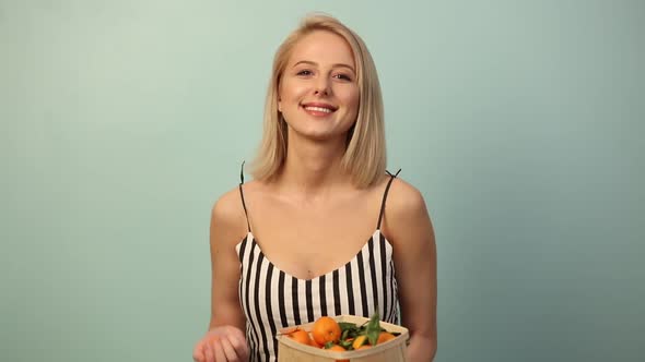 Beautiful woman with orange on blue background