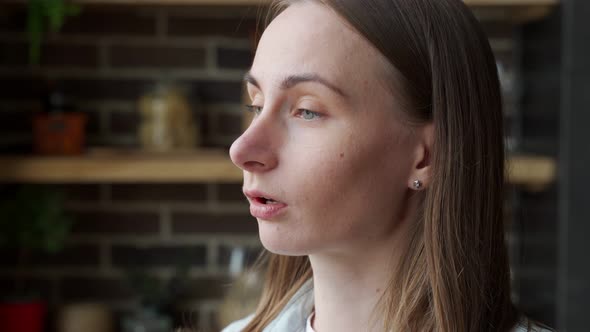 Closeup of a Young Woman's Face Eating Food with a Fork