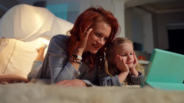 Positive Caucasian Mother and Daughter Talking Watching Cartoon Online on Tablet