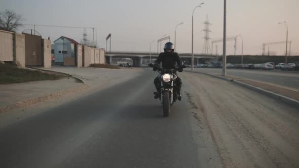 Young Attractive Man Motorcyclist with Black Helmet and Sport Motorcycle on Street