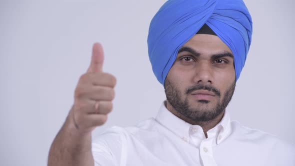 Face of Happy Young Bearded Indian Sikh Man Giving Thumbs Up
