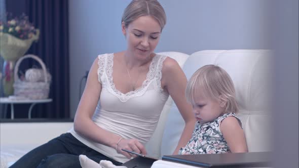 Happy Mother and Her Baby Child Using Tablet