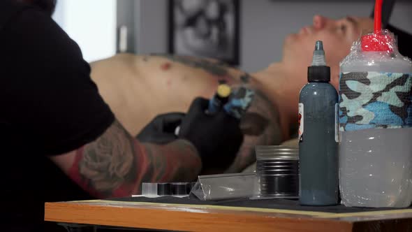 Tattoo Artist Working at His Studio, Doing a Tattoo on Chest of His Client