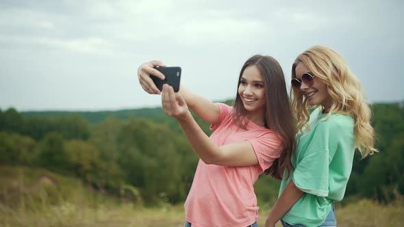 Beautiful Girls Taking Photos On Phone In Nature.