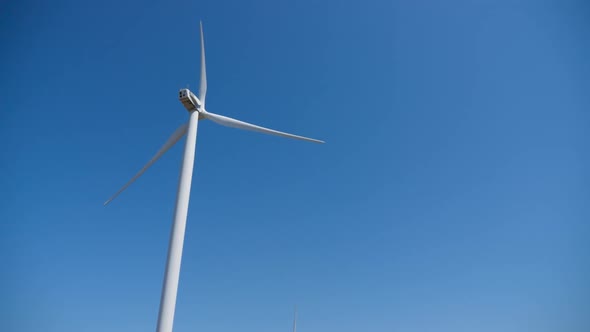 Electric Wind Turbine Stands in a Field