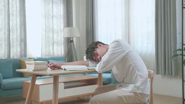 Side View Of Asian Man Student Sleeping While Studying At Home
