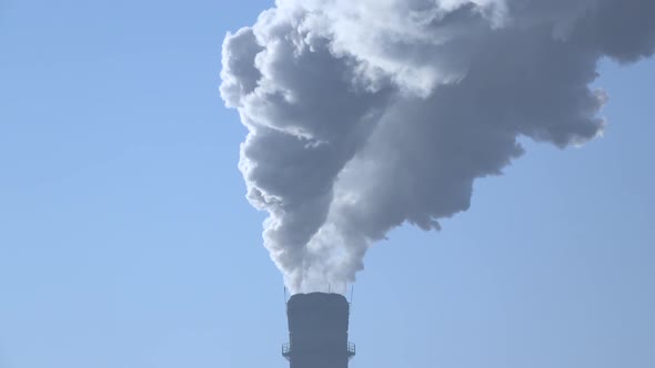 Smoke Stack with a Nice Smoke Over Blue Sky