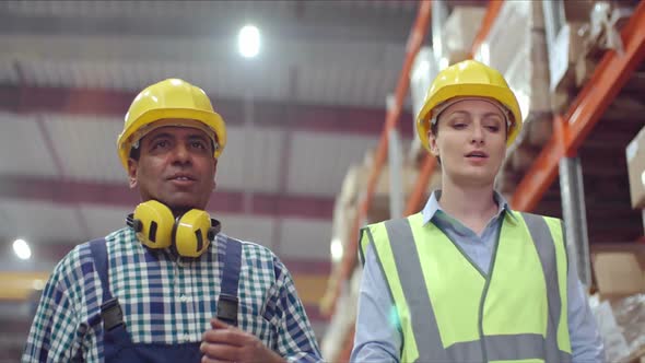 Male and Female Technicians Walking in Warehouse