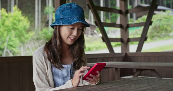 Woman use of mobile phone in the wooden house