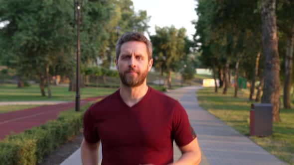 Athletic Man Running in Park Outdoor Facing Sunset Aerobic Load